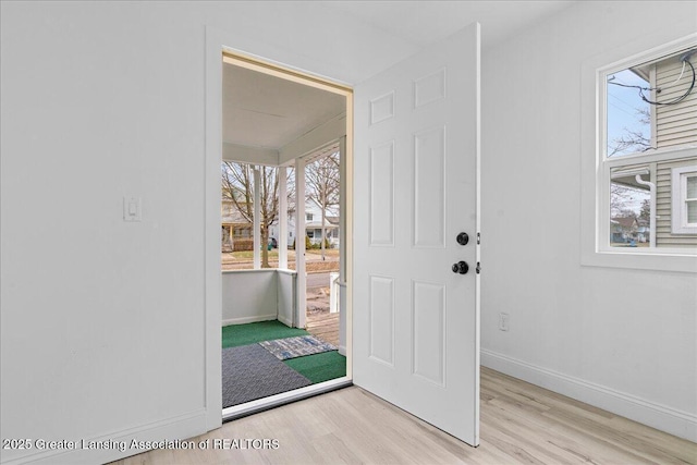 foyer entrance with baseboards and wood finished floors