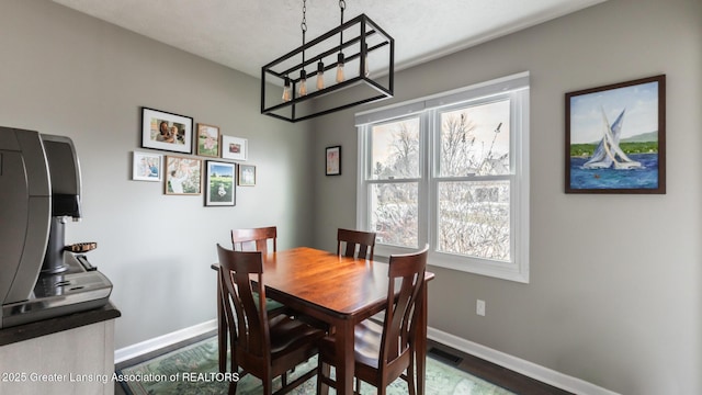 dining room with visible vents, baseboards, dark wood-style flooring, and a wealth of natural light