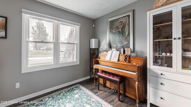 living area featuring dark wood-style flooring, a wealth of natural light, and baseboards