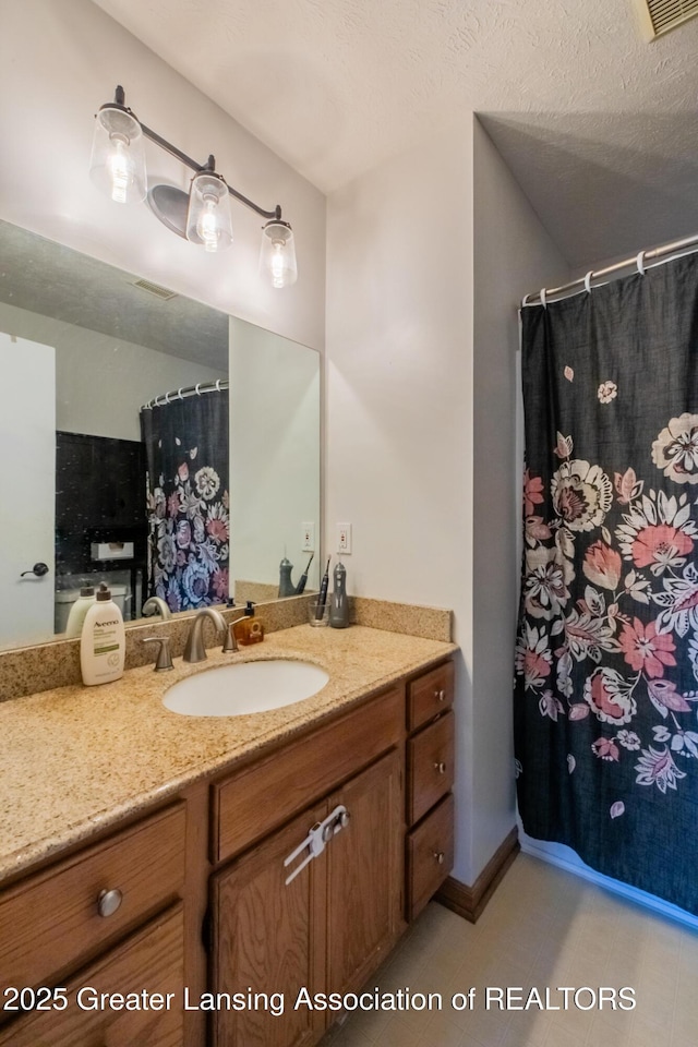 full bath with a shower with curtain, visible vents, vanity, and a textured ceiling