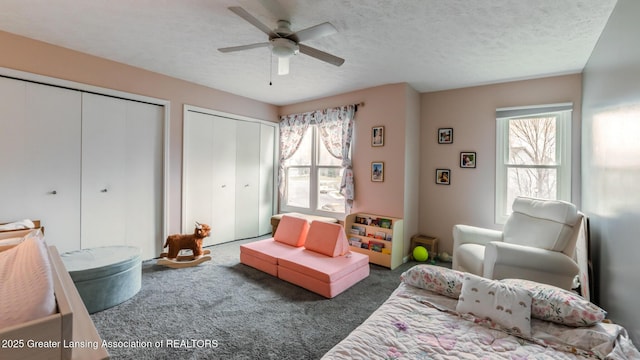 living area featuring carpet floors, a textured ceiling, and a ceiling fan