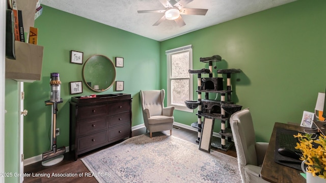 home office featuring ceiling fan, a textured ceiling, wood finished floors, and baseboards