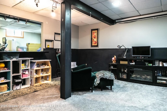 interior space with carpet floors, wainscoting, and a drop ceiling