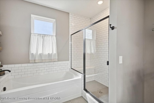 bathroom featuring a shower stall and a bath