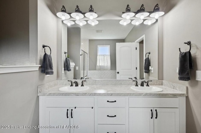 bathroom with double vanity, a stall shower, a sink, and visible vents