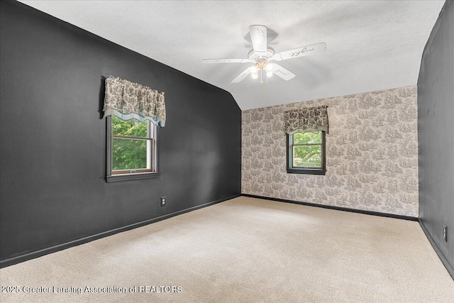 9840 W Herbison Rd, Eagle, MI 48822 - spare room with plenty of natural light, carpet floors, a ceiling fan, vaulted ceiling, and a textured ceiling