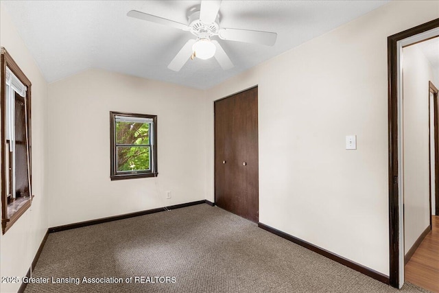 9840 W Herbison Rd, Eagle, MI 48822 - unfurnished bedroom with carpet floors, a closet, lofted ceiling, and ceiling fan