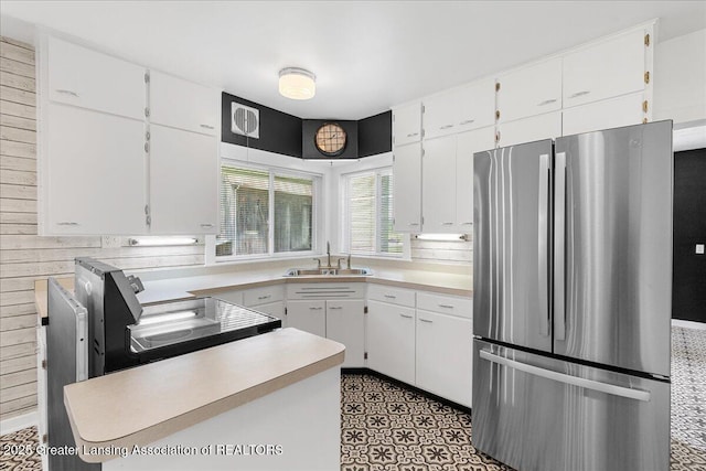 9840 W Herbison Rd, Eagle, MI 48822 - kitchen featuring freestanding refrigerator, light countertops, white cabinetry, and wooden walls