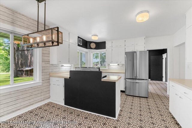 9840 W Herbison Rd, Eagle, MI 48822 - kitchen featuring freestanding refrigerator, light countertops, white cabinetry, and pendant lighting