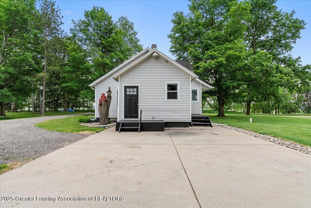 9840 W Herbison Rd, Eagle, MI 48822 - rear view of property featuring a lawn and a chimney