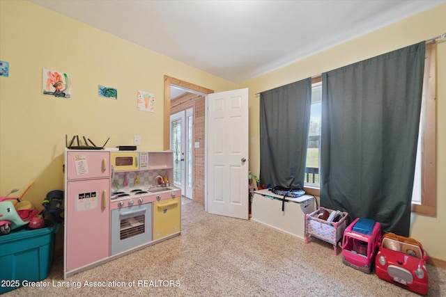 recreation room with light colored carpet