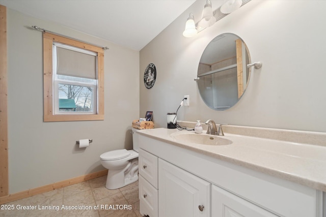 full bathroom featuring toilet, vanity, tile patterned flooring, baseboards, and walk in shower