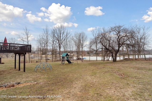 view of yard with playground community and a wooden deck