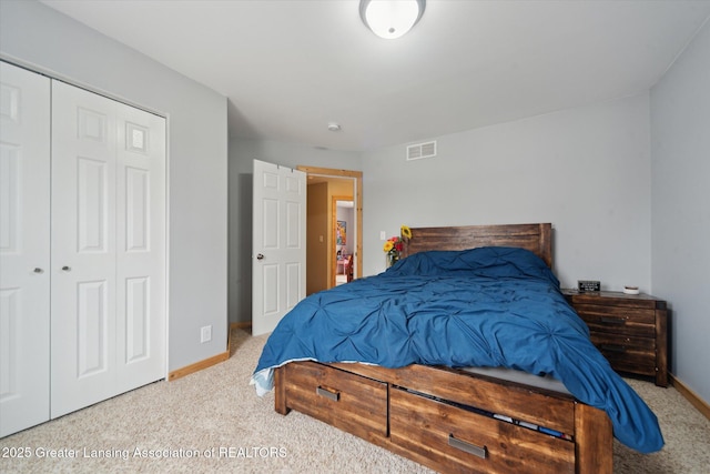 carpeted bedroom featuring a closet, visible vents, and baseboards