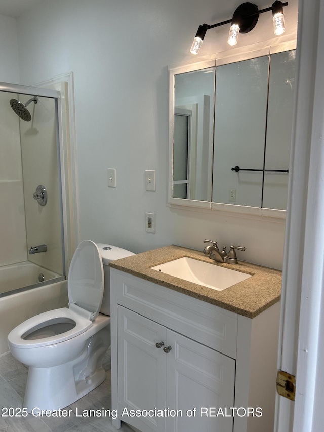 full bath featuring toilet, bath / shower combo with glass door, and vanity