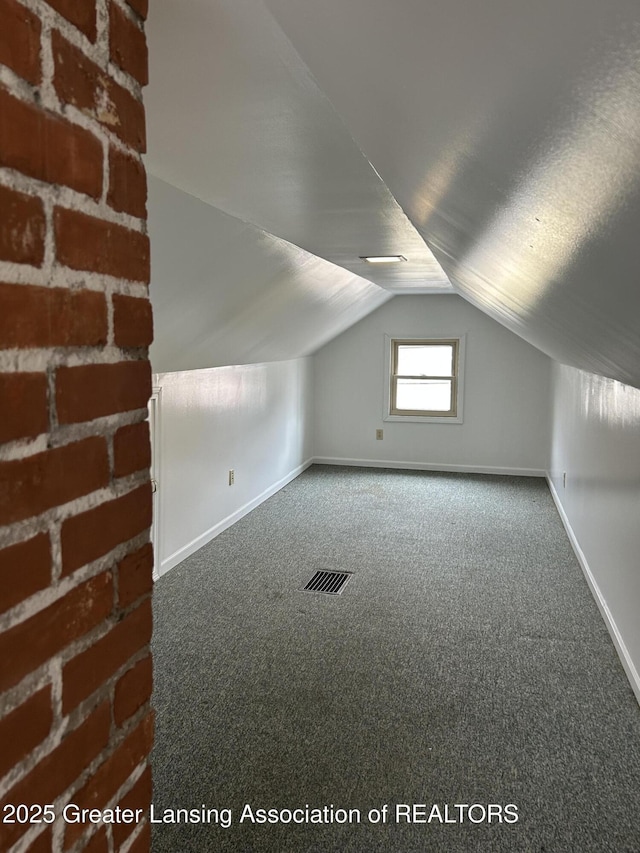 additional living space with lofted ceiling, carpet, visible vents, and baseboards