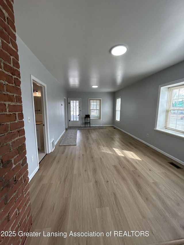 spare room featuring visible vents, baseboards, and wood finished floors