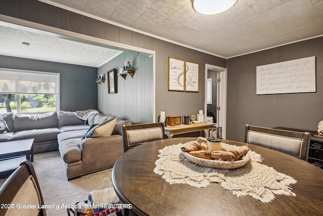 dining space featuring light carpet and ornamental molding