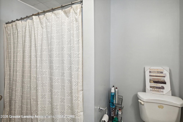 full bathroom featuring a shower with shower curtain and toilet