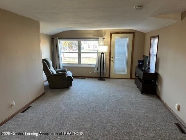 unfurnished room featuring lofted ceiling, baseboards, and visible vents