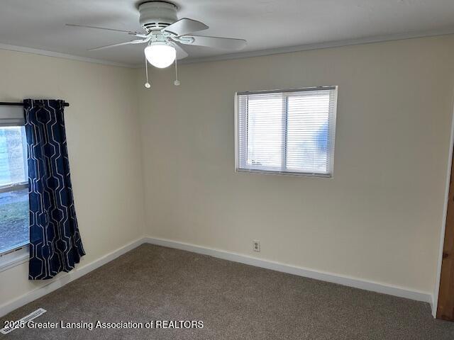 unfurnished room featuring baseboards, carpet floors, plenty of natural light, and crown molding