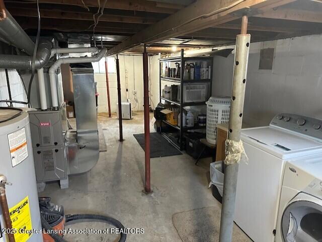 unfinished below grade area featuring gas water heater, washer / dryer, and heating unit