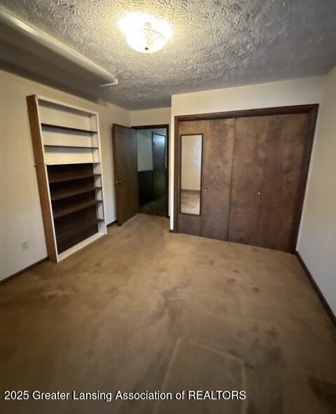 unfurnished bedroom featuring a textured ceiling and carpet