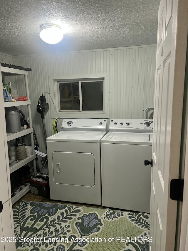 washroom featuring washer and dryer, laundry area, crown molding, and a textured ceiling