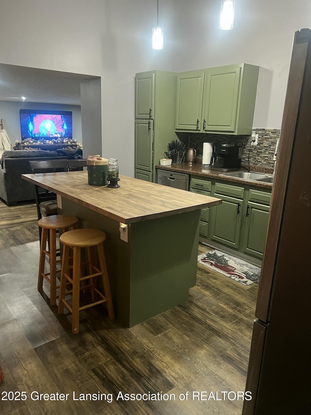 kitchen featuring dark wood-style floors, green cabinets, a kitchen island, a sink, and butcher block countertops