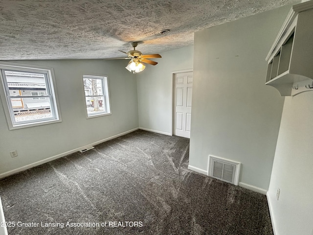 carpeted empty room featuring a ceiling fan, baseboards, visible vents, and a textured ceiling