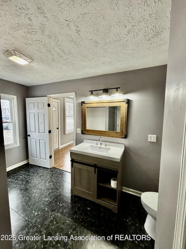 half bath featuring plenty of natural light and baseboards