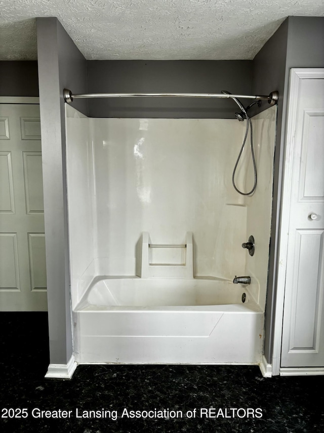 bathroom featuring tub / shower combination and a textured ceiling