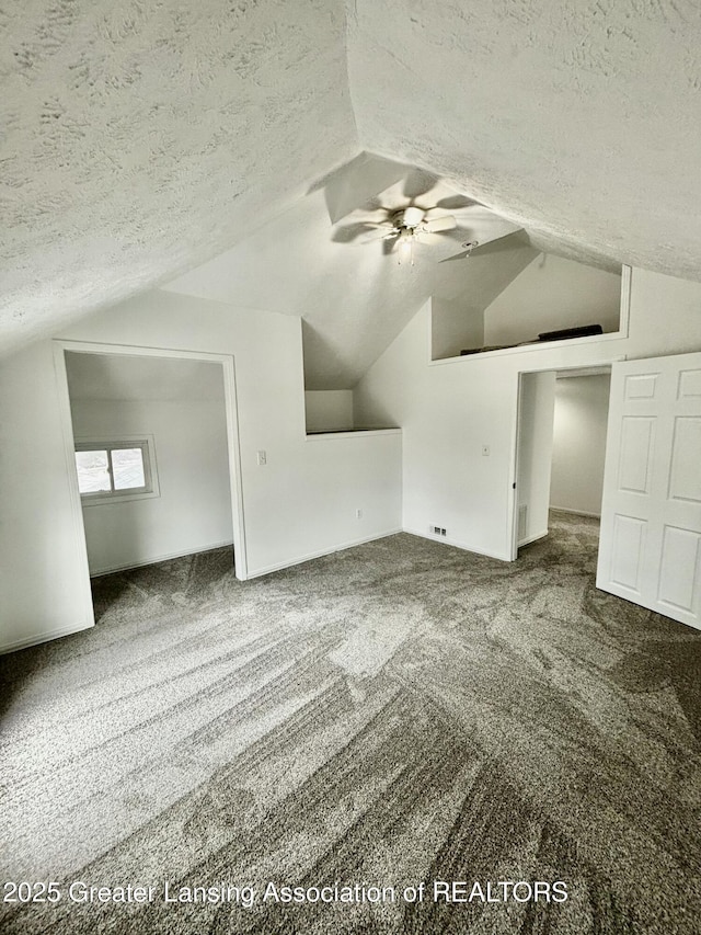 bonus room with vaulted ceiling, carpet flooring, ceiling fan, and a textured ceiling