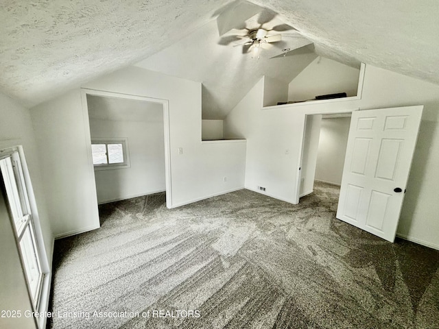 additional living space featuring a ceiling fan, carpet flooring, vaulted ceiling, and a textured ceiling