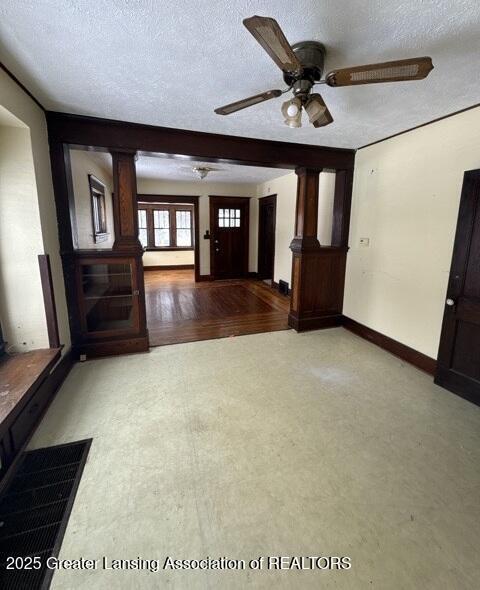 interior space featuring ceiling fan, baseboards, and a textured ceiling