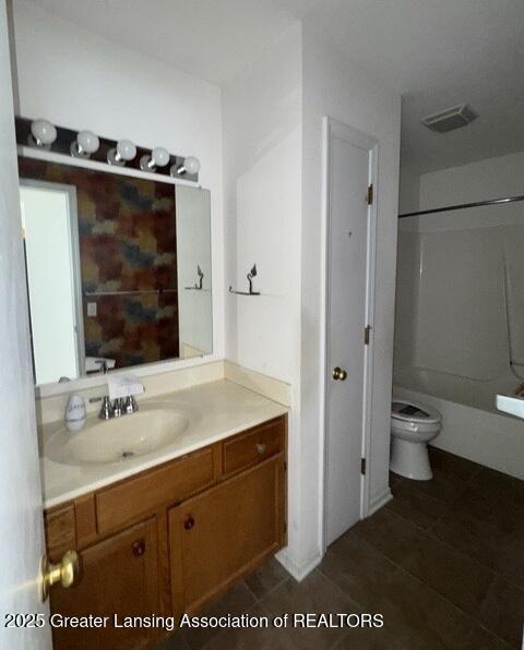 bathroom featuring toilet, visible vents, tub / shower combination, and vanity