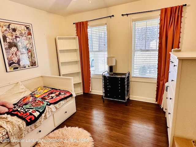 bedroom featuring dark wood-style floors, multiple windows, and baseboards