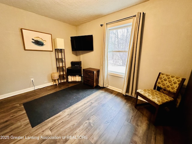 unfurnished room with a textured ceiling, dark wood finished floors, and baseboards