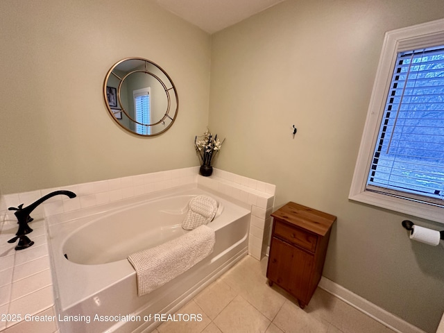 bathroom with baseboards, a bath, and tile patterned floors