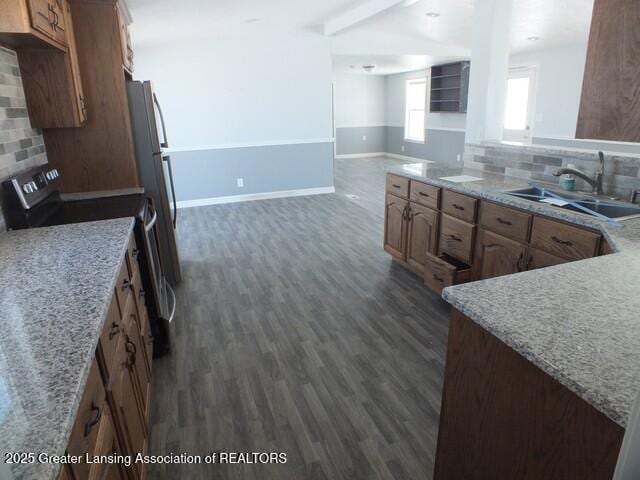 kitchen featuring tasteful backsplash, dark wood-type flooring, a sink, and stainless steel range with electric cooktop