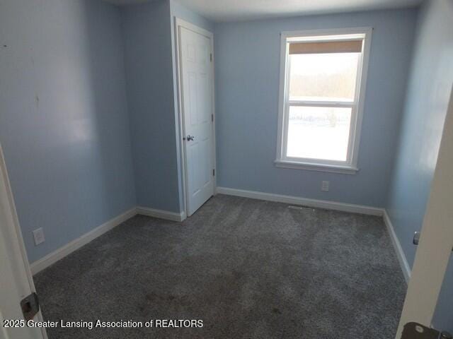 unfurnished room featuring carpet floors and baseboards