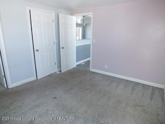 unfurnished bedroom featuring carpet flooring and baseboards