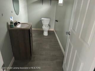 bathroom with baseboards, vanity, and toilet