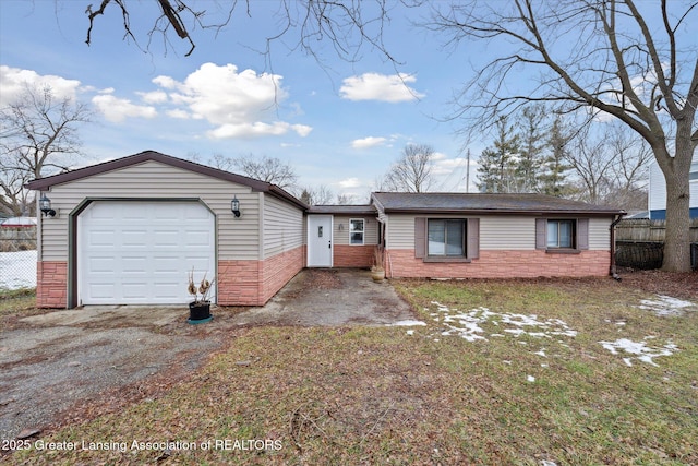 ranch-style home featuring driveway, an attached garage, and fence