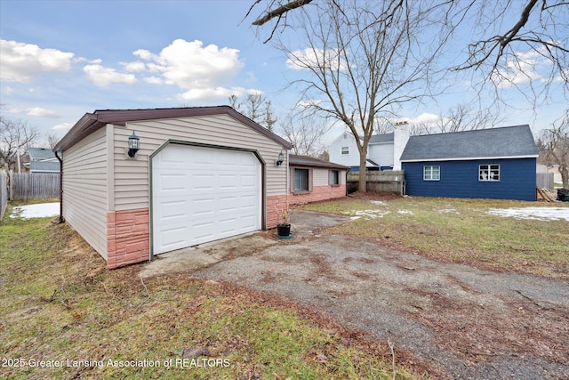 garage with driveway and fence