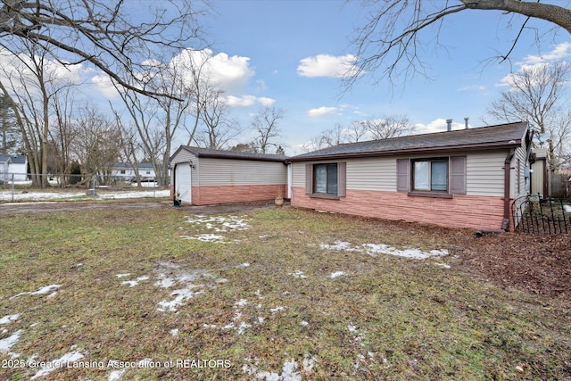 exterior space featuring a garage, driveway, a lawn, stone siding, and fence