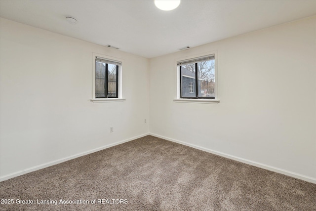 carpeted empty room featuring visible vents and baseboards