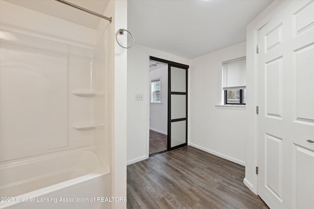 full bathroom with wood finished floors, shower / tub combination, and baseboards