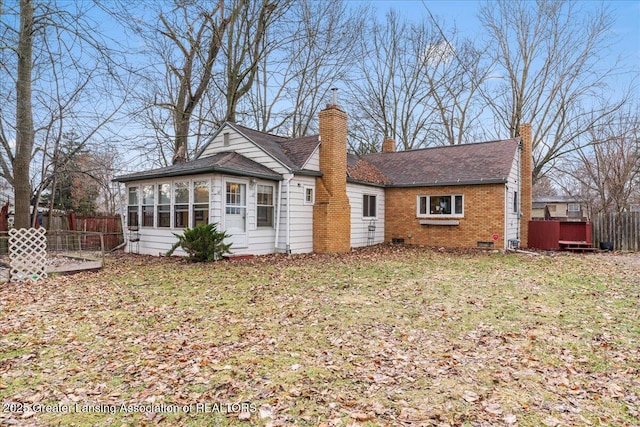 back of house with crawl space, brick siding, fence, and a chimney