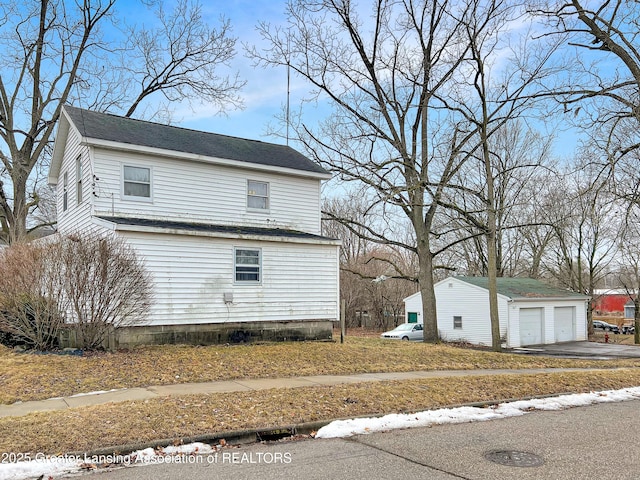 view of property exterior with a garage and an outbuilding